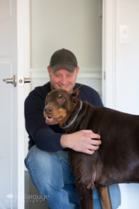 Dog being cuddle by Dad looking at camera