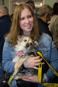 Teenage girl smiling holding small rescue dog