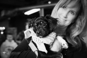 Woman holding little black rescue dog