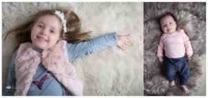 Little girl and baby sister on sheepskin rugs