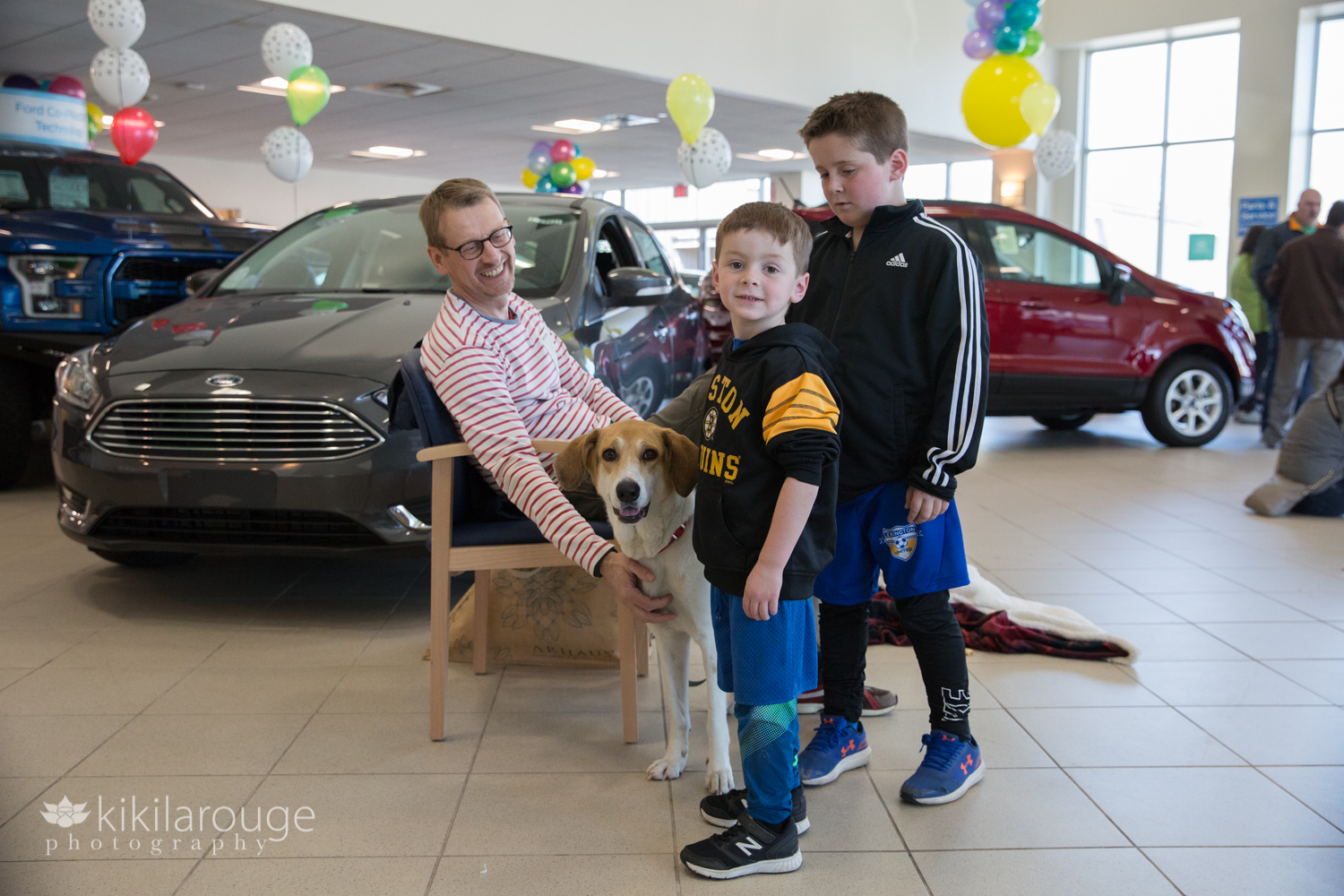 Rescue dog at car dealership with two boys