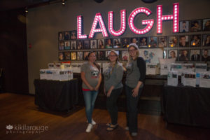 Three women volunteers for dog rescue in front to auction fundraiser