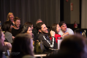 Men and Woman in audience at comedy show laughing