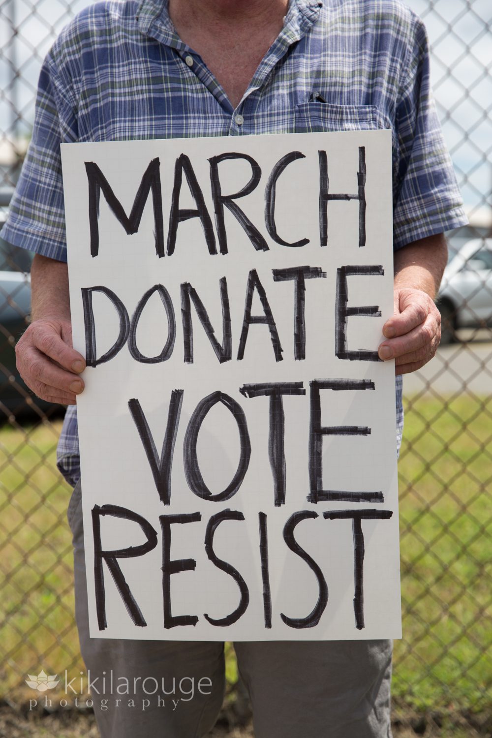 Protester holding a sign MARCH DONATE VOTE RESIST