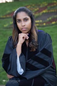 Woman sitting with cap for graduation on bench