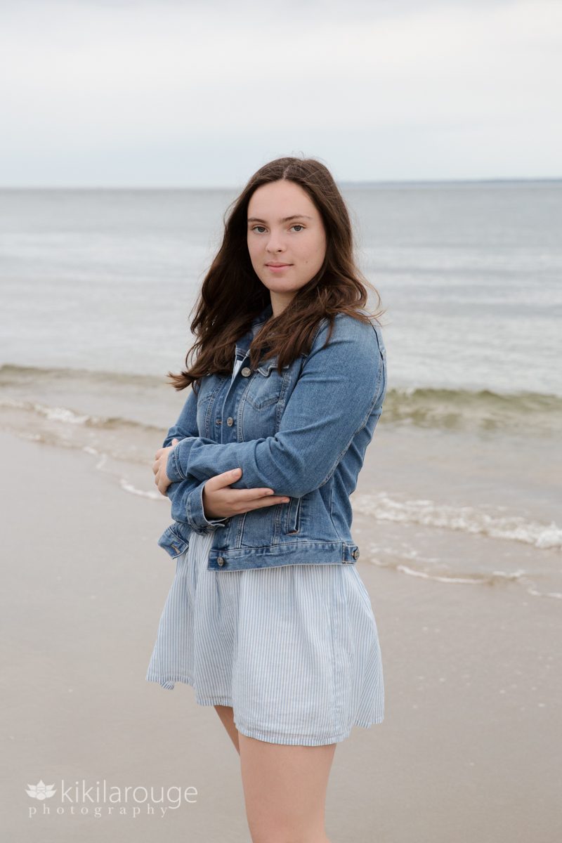 senior Portrait brunette hair and denim jacket at beach