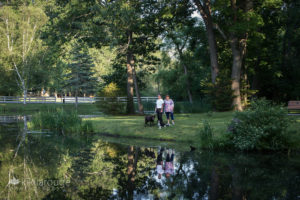 Couple with two dogs by pond with relfection