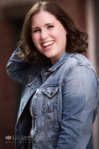 Girl laughing hand on head in denim jacket