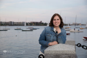 Senior Portrait of girl leaning on concrete post by water