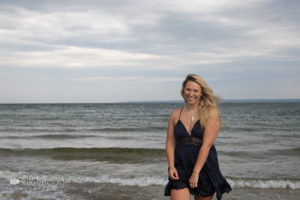 Senior girl walking out of the ocean in denim dress