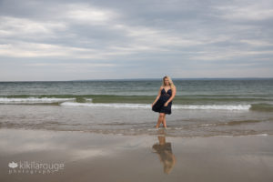 Senior girl in blue dress with reflection at beach