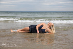 Girl laughing while laying in water at beach