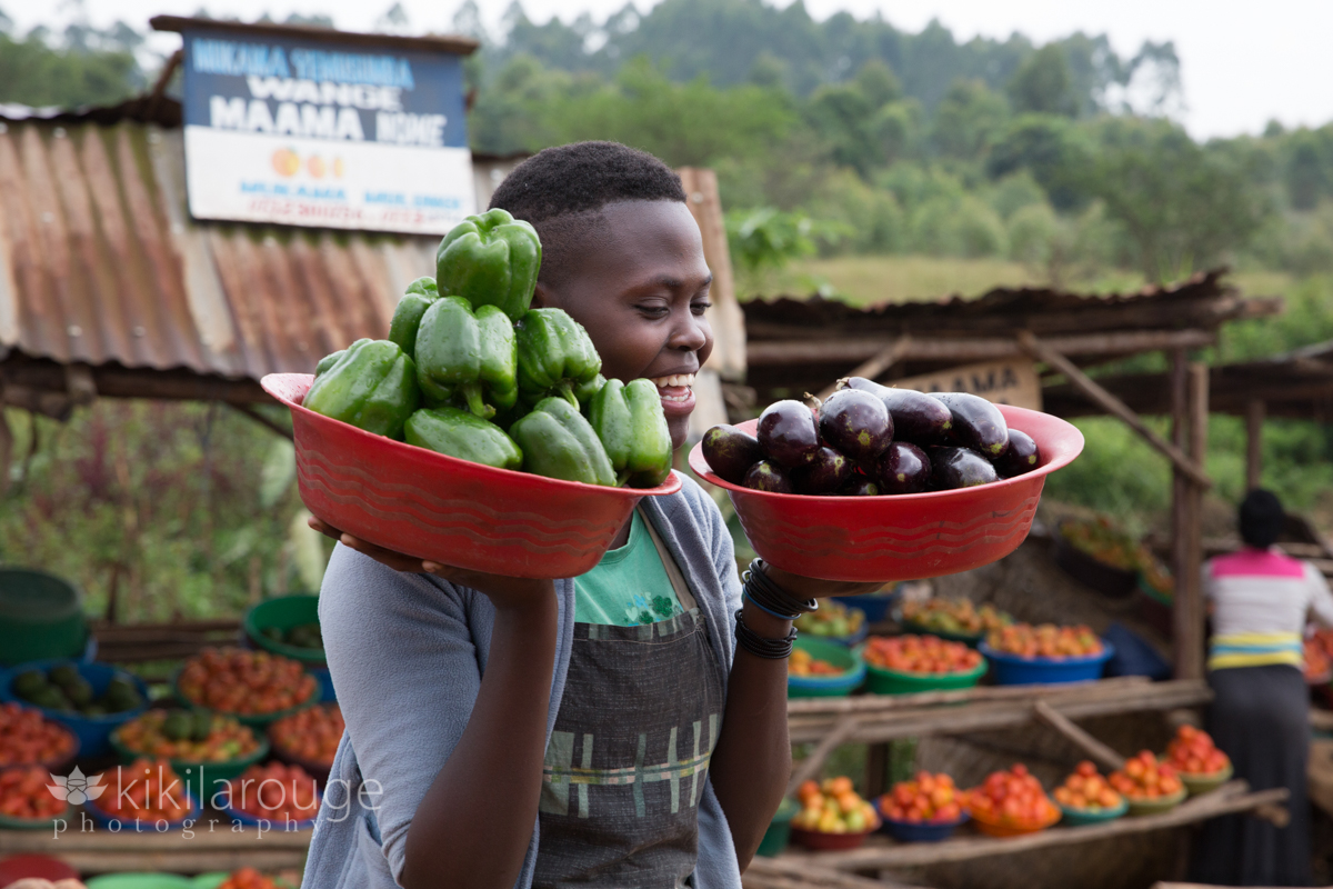 Ugandan woman selling peppers and eggplants