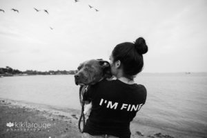 Woman in "I'm fine" shirt holding pit bull with one eye