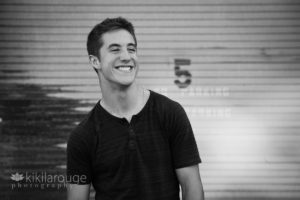 Urban photo senior boy laughing with metal backdrop