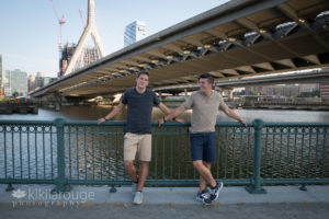 Brothers standing by railing under Zakim Bridge Boston