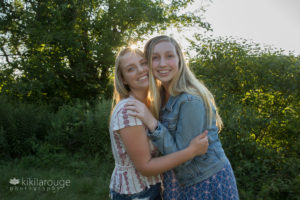 Cousins hugging smiling with sun burst