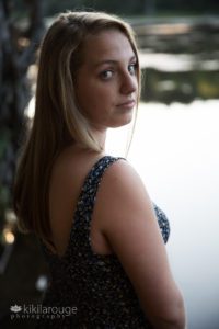 Girl blue dress looking over shoulder at pond