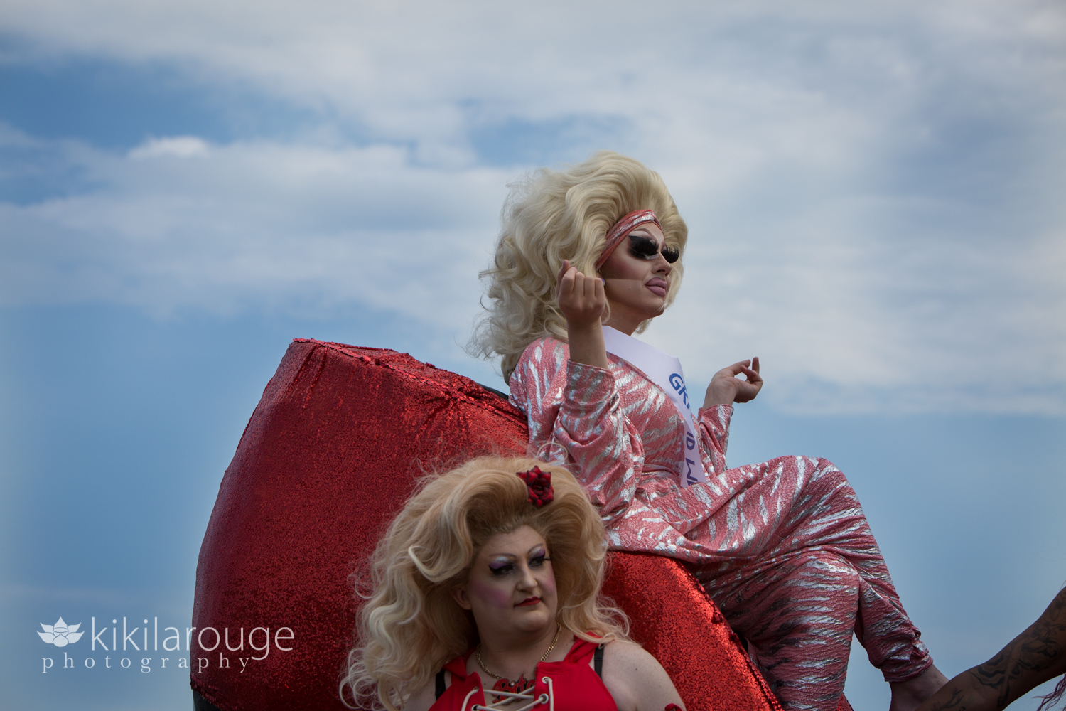 Trixie Mattel sitting on large red show on carnival float PTown
