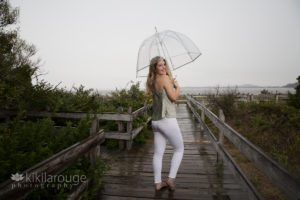 Girl in rainstorm with white jeans and clear umbrella