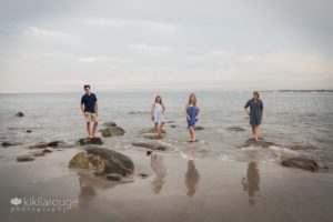 Family standing on rocks in ocean at beach