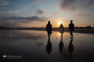 Silhoutte of three siblings walking towards sunset