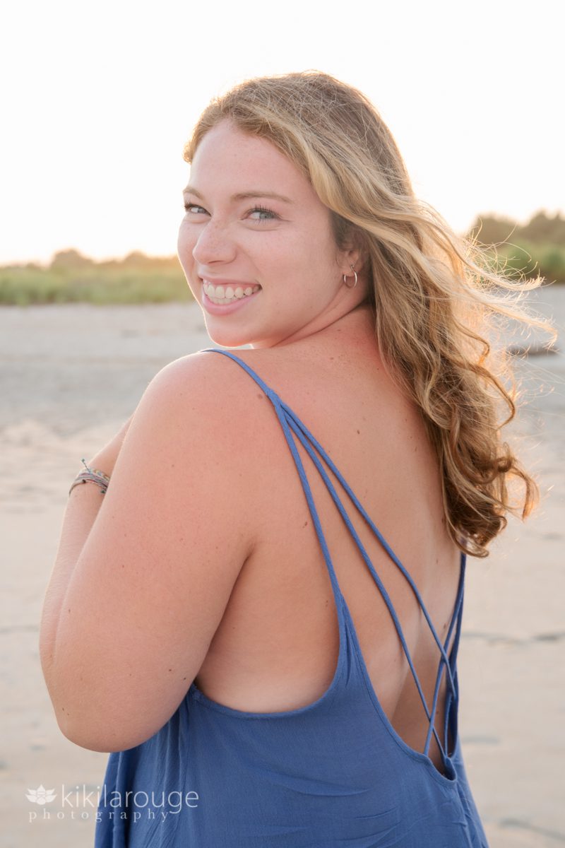 Smiling blonde woman at sunset in blue dress