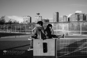 Boy and girl back to back with Seattle city line in backdrop