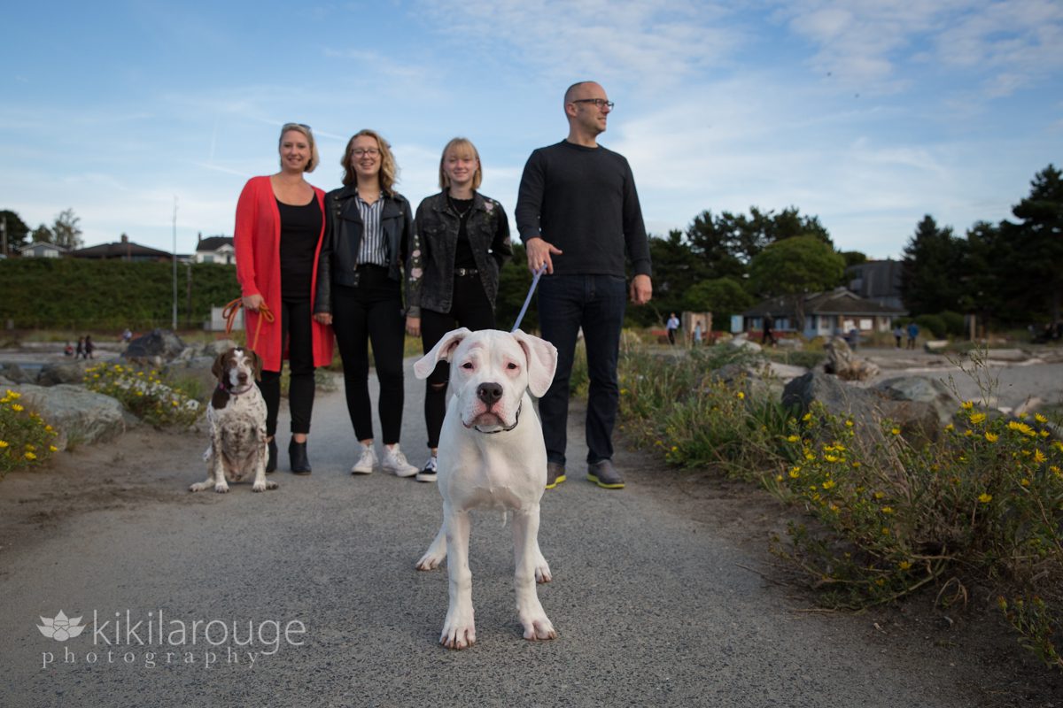 White dog looking at camera with family in backdrop