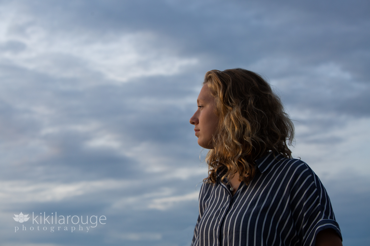 Blonde girl with sun on her face and only clouds