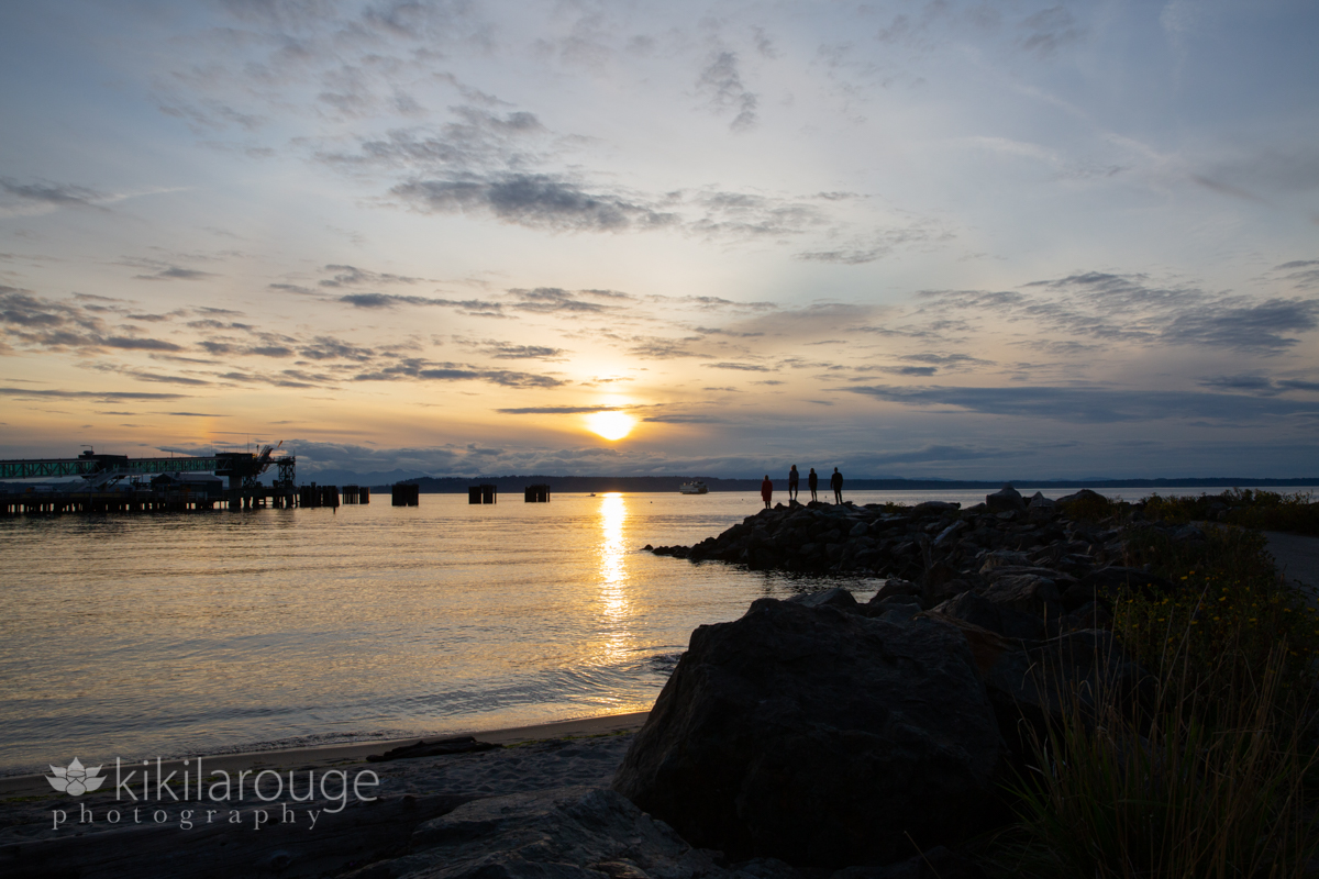 Silhouette of family at the end of jetty at sunset Seattle
