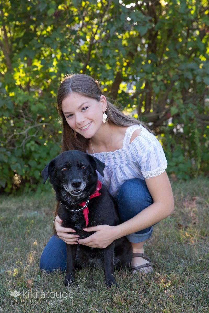 Girl with black dog with red bandana