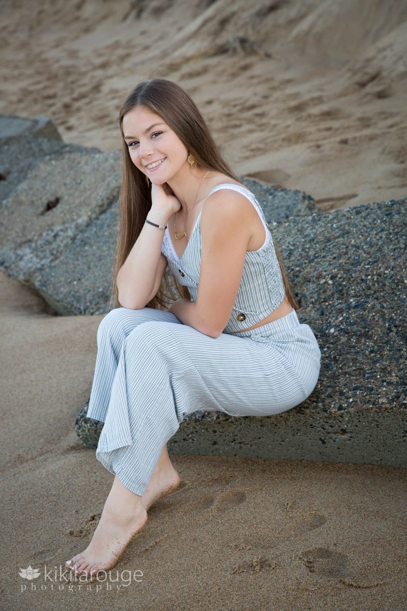 Senior girl sitting on rock at beach