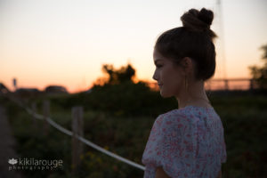 Silhouette of teen girl with hair in bun at sunset beach