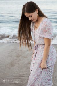 Girl at water's edge beach looking down with long hair