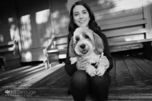 Teen girl holding her havanese dog on porch