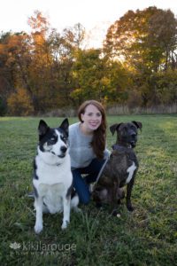 Redhead in jeans with two dogs on either side