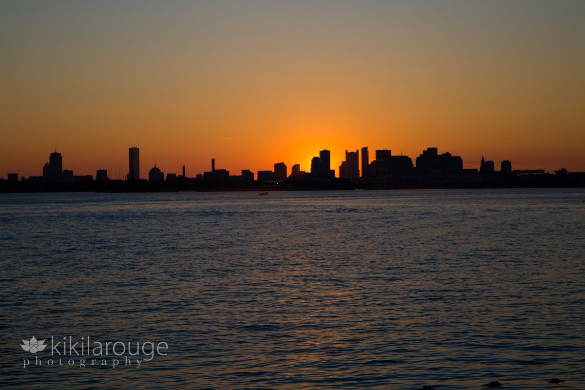 Bright Orange Sunset and silhouette of Boston Skyline from Harbor Islands