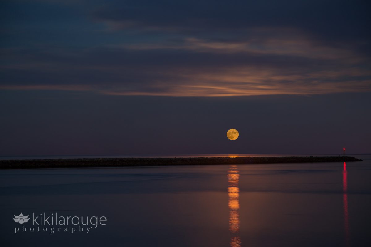 The red supermoon rising above jetty at Plum Island