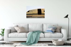 Boy in abandoned plane Uganda print on wall above sofa