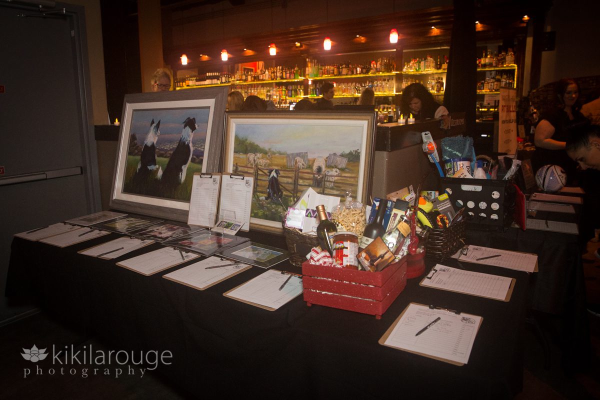 A silent auction table with bar in the background
