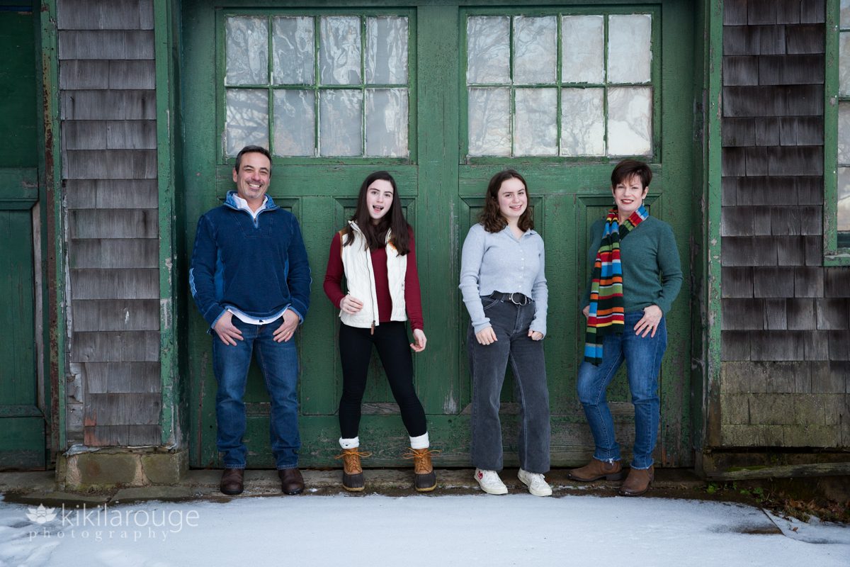 Family of four portrait against a green barn door