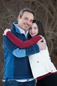 Dad hugging his teen daughter