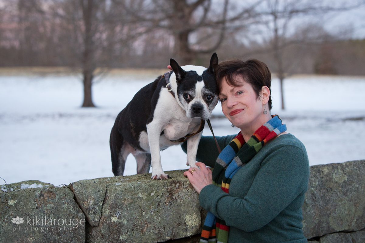 Woman in green shirt with colorful scarf with her Boston Terrier family dog