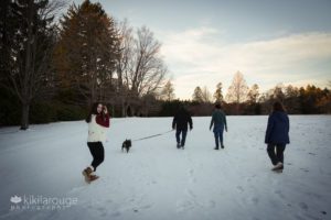 Family Walking across snowy field with dog