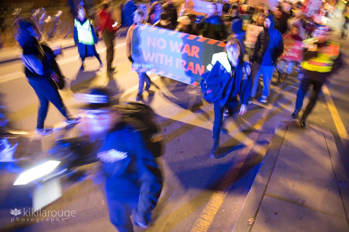 Slow shutter movement of protesters walking in streets of Harvard Square