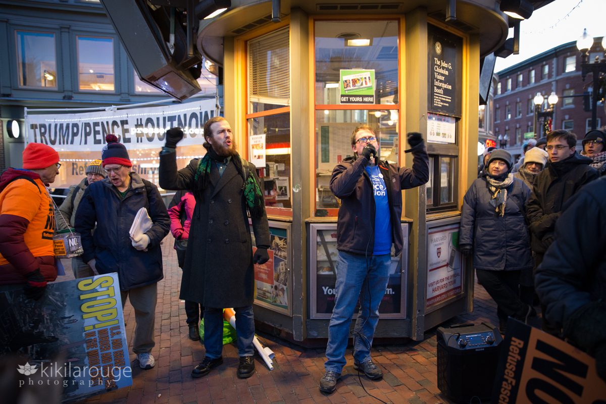 Men speaking with microphone at anti war protest in Harvard Square center