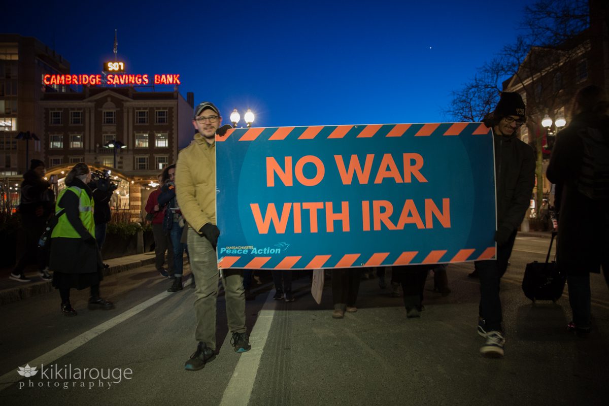 No War with Iran sign being held and walked in front of protest march