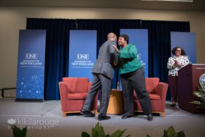 Two people hugging after an event at UNE