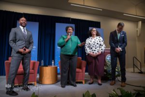 People on stage at UNE laughing at Abrams joke